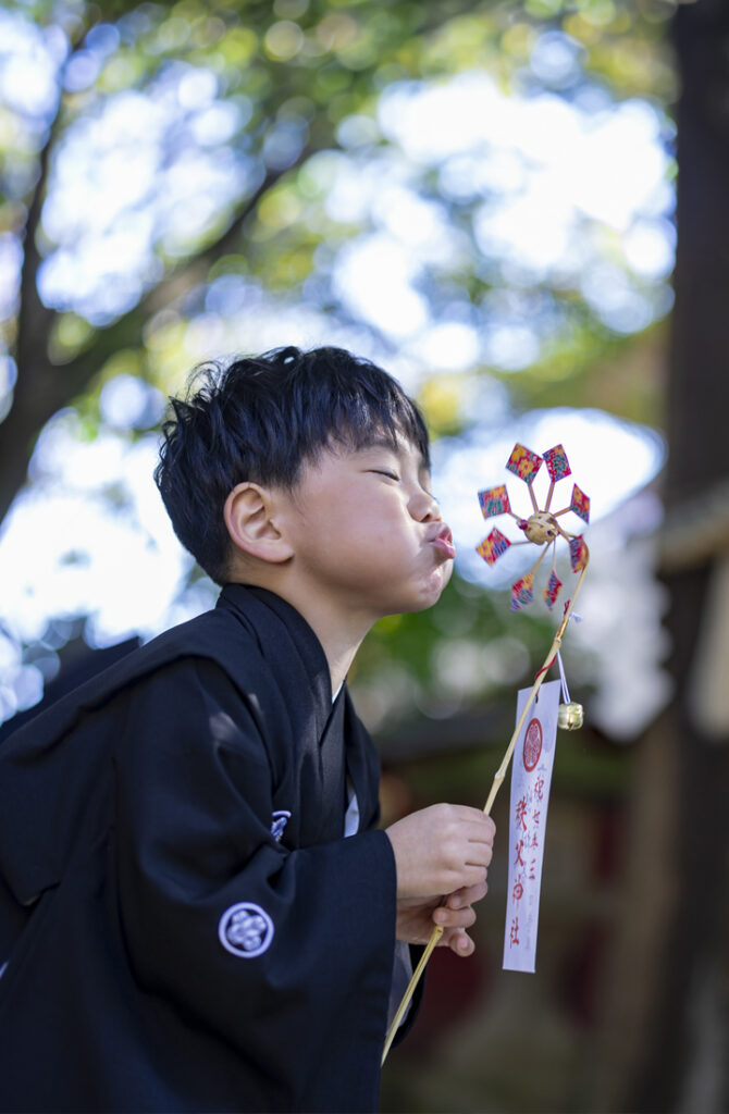 七五三の五歳記念写真、秩父神社で風車を楽しそうに回す着物姿の男の子