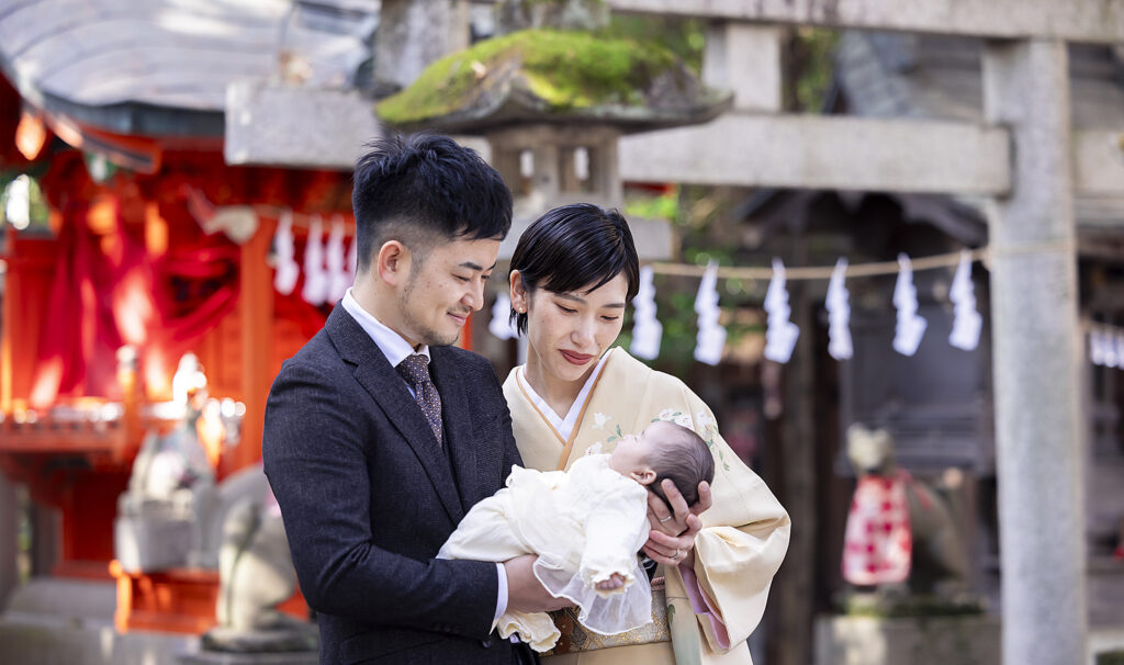 秩父神社でのお宮参りの記念写真。両親がお子様を笑顔で見つめる様子
