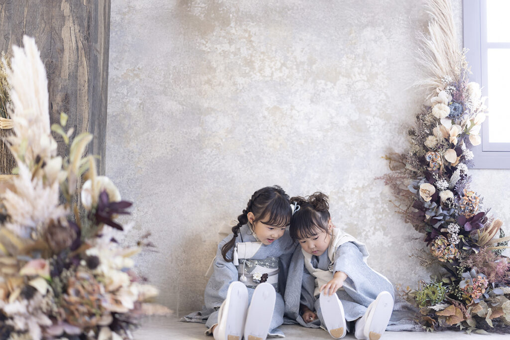 七五三の7歳と3歳の姉妹、水色のモダンな着物でスタジオ撮影、自然な笑顔の写真