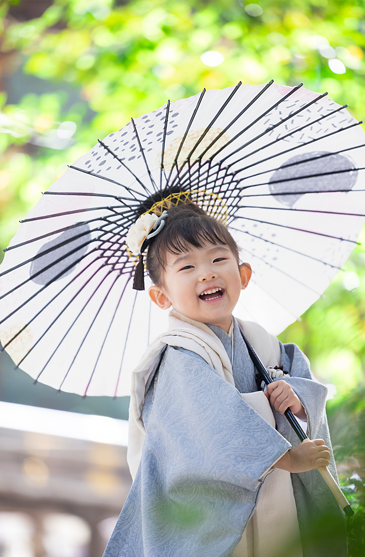 七五三の三歳の女の子。モダンな赤い着物を着た女の子。秩父神社で番傘を指して撮影。