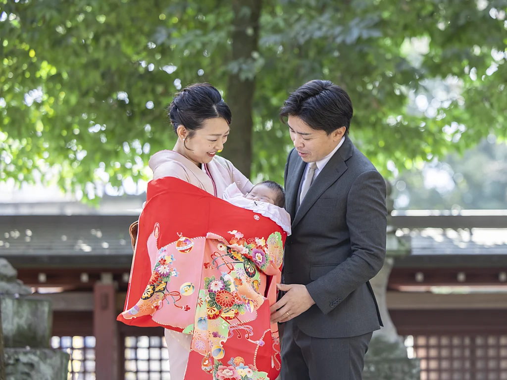 秩父神社でお宮参りの様子。赤い祝い着をかけて笑顔の写真。