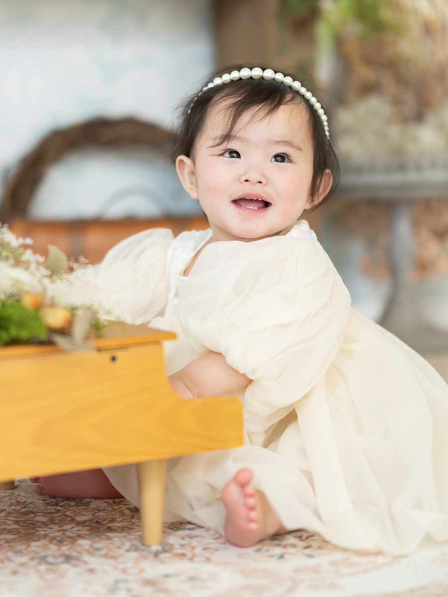 かわいいドレスを着て笑顔を見せる女の子のバースデーフォト