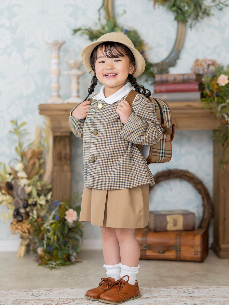 園服を着て笑顔を見せる幼稚園入園記念の子ども